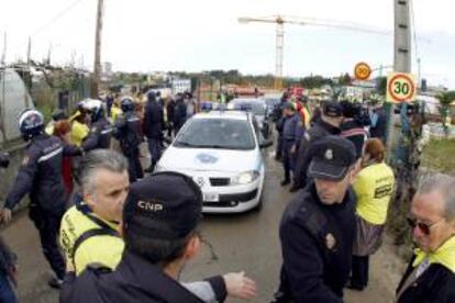 Efectivos de la polica junto a los afectados por las participaciones preferentes que se han concentrado hoy ante la explanada de la nueva depuradora de Vigo, donde han retenido en el interior de las instalaciones durante unos 45 minutos a las autoridades que realizaban una visita a las obras de esta infraestructura.Entre las autoridades figuraban el delegado del Gobierno en Galicia, Samuel Jurez, el conselleiro de Medio Ambiente, Agustn Hernndez, el subdelegado del Gobierno, Antonio Coello, y la directora general de Aquanorte, Isabel Prez-Espinosa, entre otras.