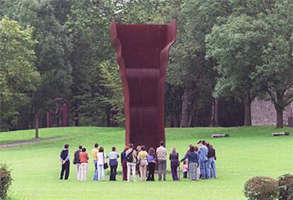 Un grupo de visitantes, ante la escultura <b><i>Buscando la luz I</b></i> (1998), en el Museo Chillida-Leku, en Hernani (Guipúzcoa).