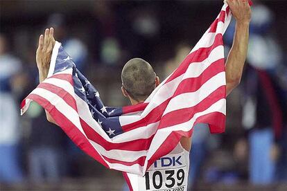 Jeremy Wariner, con la bandera de su país, tras ganar los 400 metros.