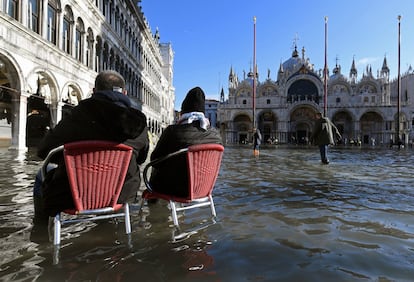 Las personas se sientan en sillas en la inundada plaza de San Marcos durante en plena 'aqua alta' en Venecia, el 14 de noviembre.