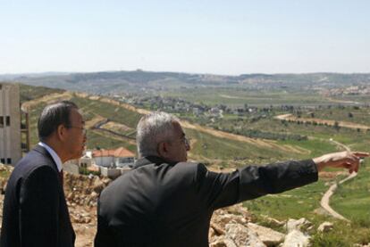 El secretario general de la ONU, Ban Ki-moon (izquierda), escucha las explicaciones del primer ministro palestino, Salam Fayad, mientras este señala al muro que Israel está construyendo en Cisjordania.