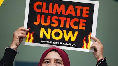 Una manifestante sostiene un cartel que dice "Justicia climática ahora" durante una acción en la Cumbre del Clima de la ONU COP29, el 18 de noviembre en Bakú, Azerbaiyán.