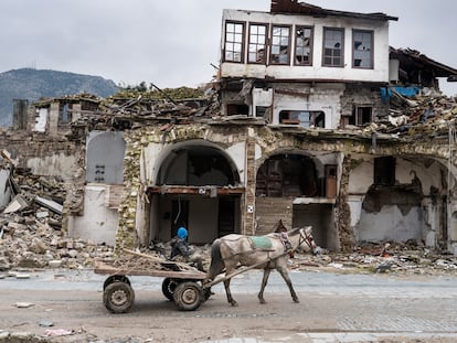 Un hombre pasa con su carromato junto a un edificio destruido por el terremoto en Antioquía, provincia de Hatay, el 31 de enero.
