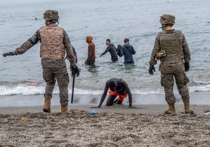 Un hombre llega a la playa mientras el Ejército acordona la zona, este martes.