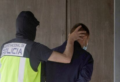 Un agente traslada a uno de los seis detenidos por la muerte de Samuel Luiz, el viernes pasado en el edificio de los juzgados de A Coruña.