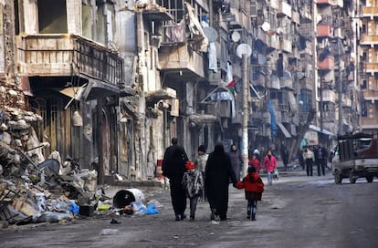 Un grupo de ciudadanos sirios caminan por una calle destruida en Alepo (Siria).