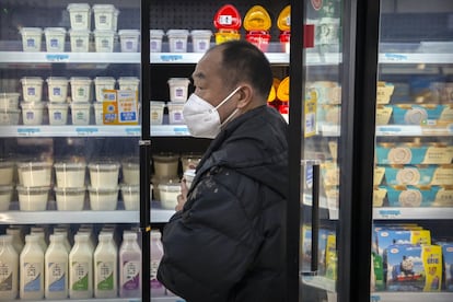 Un hombre usa una máscara facial mientras compra alimentos en un supermercado de Pekín, este martes, 28 de enero.