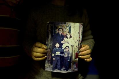 In this Thursday, Jan. 19, 2017 photo, Fidan Kiru, 31, a Syrian refugee from Afrin, holds a photograph taken in 2004 showing herself and her husband Mohyeddin, when he was 27-year-old, and her sons, younger to older, Avindar, 8 months, Khalid, 4 and Levant, 6, at her tent in Kalochori refugee camp on the outskirts of the northern Greek city of Thessaloniki. "This is the only group family picture we have, my husband is currently in Germany and I hope they will allow me to join him." Fidan said. (AP Photo/Muhammed Muheisen)