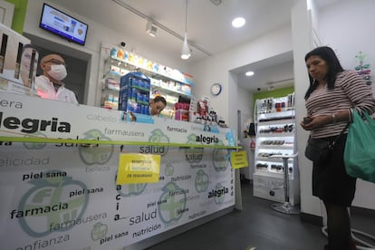 En establecimientos donde se atiende al público, como en las farmacias, se están aplicando medidas como la distancia de seguridad para evitar el contagio del virus. En la imagen, una farmacia en el distrito de Usera en Madrid.