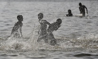 Un grupo de niños se baña en un estanque en Nueva Delhi (India).