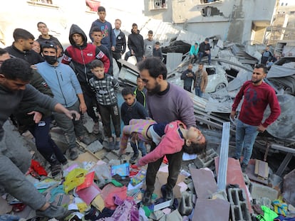 Un hombre saca el cuerpo de un menor de entre los escombros de un edificio bombardeado por Israel en la franja de Gaza.
