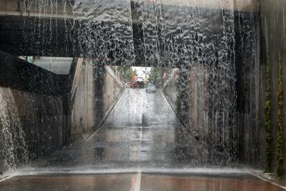 Vista general del agua que cae en el paso inferior a la entrada de San Vicente desde la carretera de La Alcoraya que ha sido cortado por las intensas lluvias.