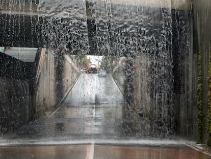 Vista general del agua que cae en el paso inferior a la entrada de San Vicente desde la carretera de La Alcoraya que ha sido cortado por las intensas lluvias.