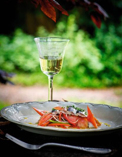´<p><b>Mantenerse en frío.</b> Las sardinas se deben cubrir con aceite de girasol porque permite conservarlas durante varios días en la nevera. Este aceite no cuaja con el frío y facilita la manipulación del producto. En esta receta es importante que el sabor del tomate prevalezca sobre las verduras, pues este es la base del trampó..</p><p><em> Ingredientes.</em> Para dos personas: un tomate corazón de buey, un pimiento rojo, un pimiento verde, ½ cebolla tierna, aceite, vinagre, sal y pimienta. Para las sardinas: cuatro filetes de sardinas frescas, 50 gramos de vinagre, 200 gramos de agua, aceite de girasol y escamas de sal..</p><p><em> Preparación:</em> 1. Marinar las sardinas con el agua y el vinagre durante seis horas en la nevera. 2. Retirar las sardinas, secar, cubrir en aceite de girasol y reservar. 3. Para la ensalada, cortar todas las verduras en juliana (en vez de a dados como la receta original del trampó), aliñando primero la cebolla y los pimientos y dejándolos marinar una hora en la nevera. 4. Añadir el tomate cortado a gajos finos y acabar incorporando las sardinas y el resto del aliño. 5. Aderezar con escamas de sal. </p>