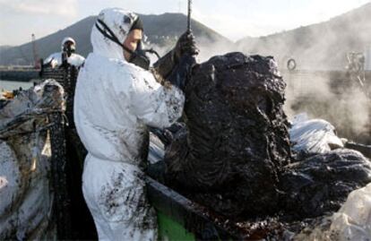Pescadores de Santurtzi (Vizcaya) descargan el fuel del <i>Prestige</i> recogido ayer.