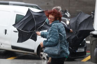 Una viandante se enfrentaba este jueves a las fuertes rachas de viento mientras caminaba por una calle del centro de Madrid.