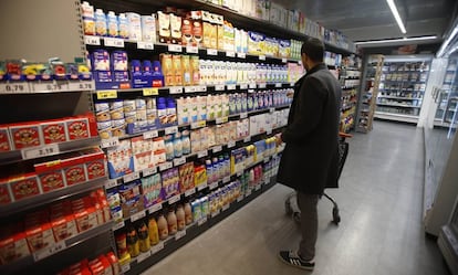 Un consumidor en la sección de lácteos de un supermercado.