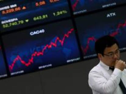 Un hombre en la sede del Korea Exchange Bank junto a unas pantallas informativas que muestran el índice Kospi en Seúl (Corea del Sur). EFE/Archivo