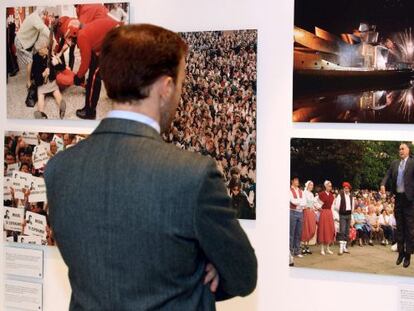 Una persona observa varias fotografias que componen la exposición "Efe, 75 años en fotos.