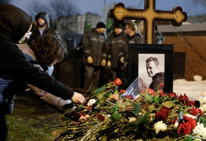 Ciudadanos depositan flores en la tumba de Alexéi Navalni.