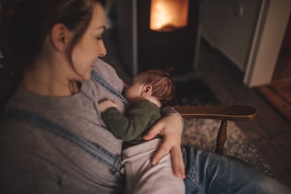 Una mujer duerme a un bebé sobre su regazo.