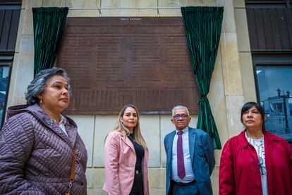 Giovana Soto y familia, posan para un retrato frente a la placa hecha en conmemoración a las víctimas de la toma del palacio de justicia en Bogotá, Colombia