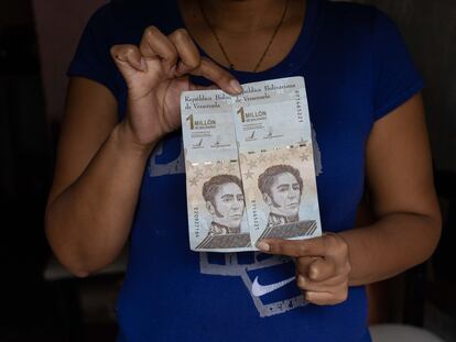 Una mujer muestra billetes de bolívares, este jueves en Caracas.