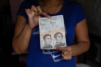 Una mujer muestra billetes de bolívares, este jueves en Caracas.