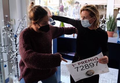 Dos trabajadores de la administración de lotería de Punta Umbría (Huelva) celebran el Gordo del sorteo de Navidad.