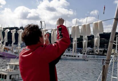 Un pescador tiende calamares al sol en el puerto de (la otra) Nagoya, Japón