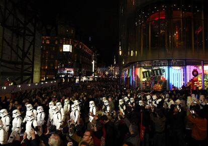 Entusiastas observan como un pelotón de soldados de asalto marcha a través de Leicester Square en el estreno europeo de Star Wars, en Londres.