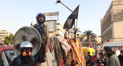 Ahmed Nuri Hasan, en el centro y con una parabólica de escudo, durante las protestas en Bagdad.