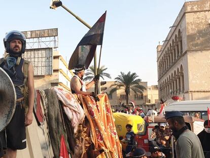 Ahmed Nuri Hasan, en el centro y con una parabólica de escudo, durante las protestas en Bagdad.