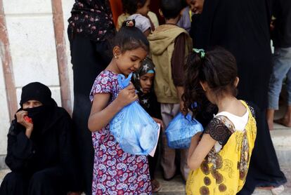 Una niña yemení desplazada que huyó a su casa en la ciudad de Hodeidah, devastada por la guerra, recibe alimentos de una organización benéfica en la capital, Saná.