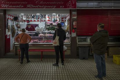 Varios clientes hacen cola manteniendo una distancia de seguridad, este lunes en el mercado del Tiro de Línea de Sevilla.