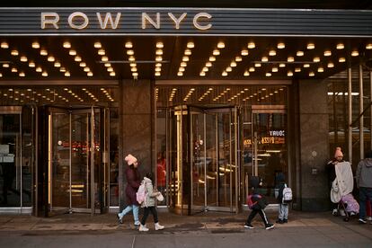 A migrant woman leaves the Row Hotel accompanied by her daughter on December 12, 2023.