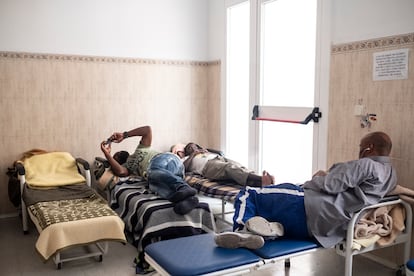 Varias personas descansan en la habitación para los hombres del Centro Municipal para Personas sin Hogar de Pozas, en Malasaña.