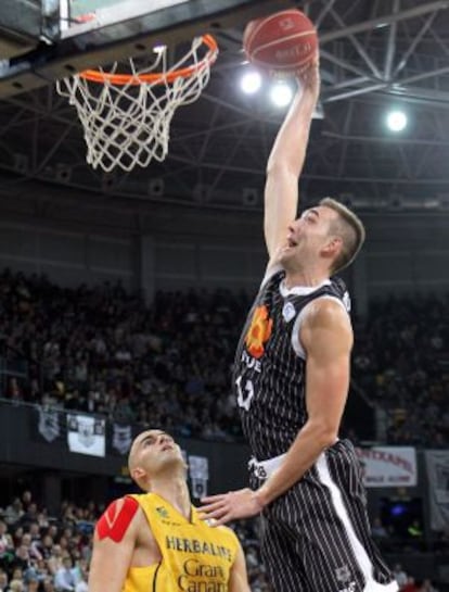 El pívot del Bilbao Basket Axel Hervelle entra a canasta ante la mirada de Xabi Rey.