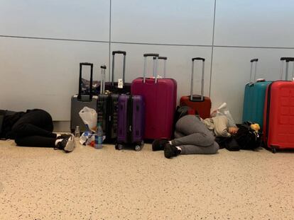 Dos pasajeros duermen en el interior del aeropuerto JFK, en Nueva York (Estados Unidos), tras el retraso de varios días sufrido en el vuelo 2036 de British Airways.