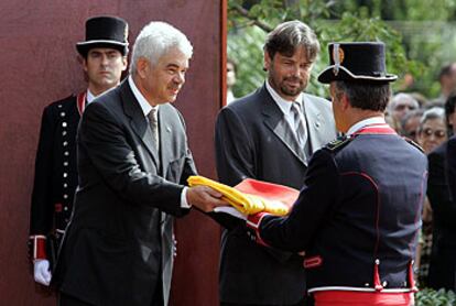 Maragall, junto a Benach, entrega la <i>senyera</i> al jefe de la formación de los Mossos d&#39;Esquadra durante el acto de ayer en el parque de la Ciutadella.