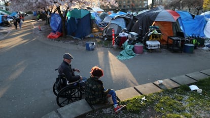 Dos personas conversan cerca de un campamento de sin techo en el Parque Oppenheimer de Vancouver, Canadá, en abril de 2020.