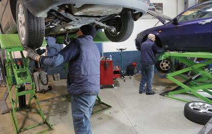 Dos trabajadores reparan coches en un taller de mecánica, en San Sebastián.