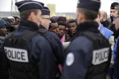 Agentes de policía franceses vigilan las filas donde se registran los migrantes antes de ser evacuados del campamento de Calais.