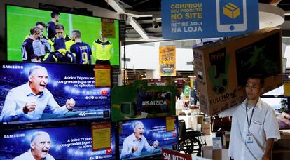 Un empleado carga un televisor en una tienda de productos electrónicos, en Sao Paulo.