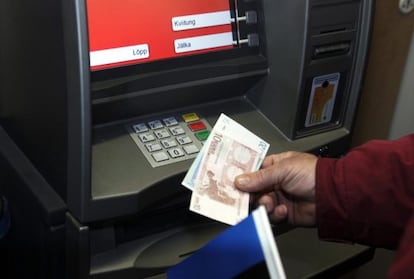 Un hombre retira euros de un cajero automático.