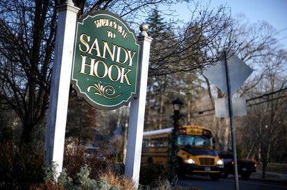 A bus drives past a sign reading Welcome to Sandy Hook in Newtown, Conn., Dec. 4, 2013.