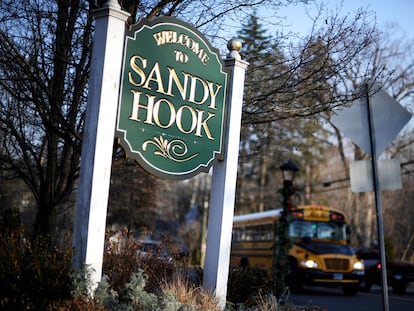 A bus drives past a sign reading Welcome to Sandy Hook in Newtown, Conn., Dec. 4, 2013.