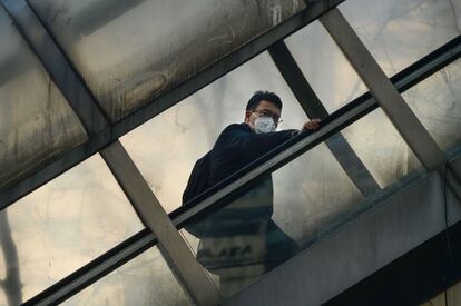 Al menos 22 ciudades han presentado alertas rojas por polución, lo que incluye las urbes de Tangshan, donde se fabrican grandes cantidades de acero, y Jinan, una localidad productora de carbón. En la imagen, un hombre con mascarilla sube por unas escaleras mecánicas en Pekín (China).