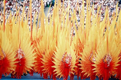 Un grup de persones apareixen disfressades de "flames" i porten màscares on predominen els colors groc i vermell durant la cerimònia.