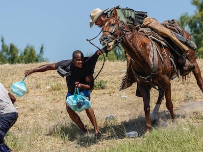 Un agente a caballo de la Patrulla Fronteriza de Estados Unidos intenta evitar que un migrante haitiano llegue al campamento a orillas del río Grande cerca del puente que une Texas y México.